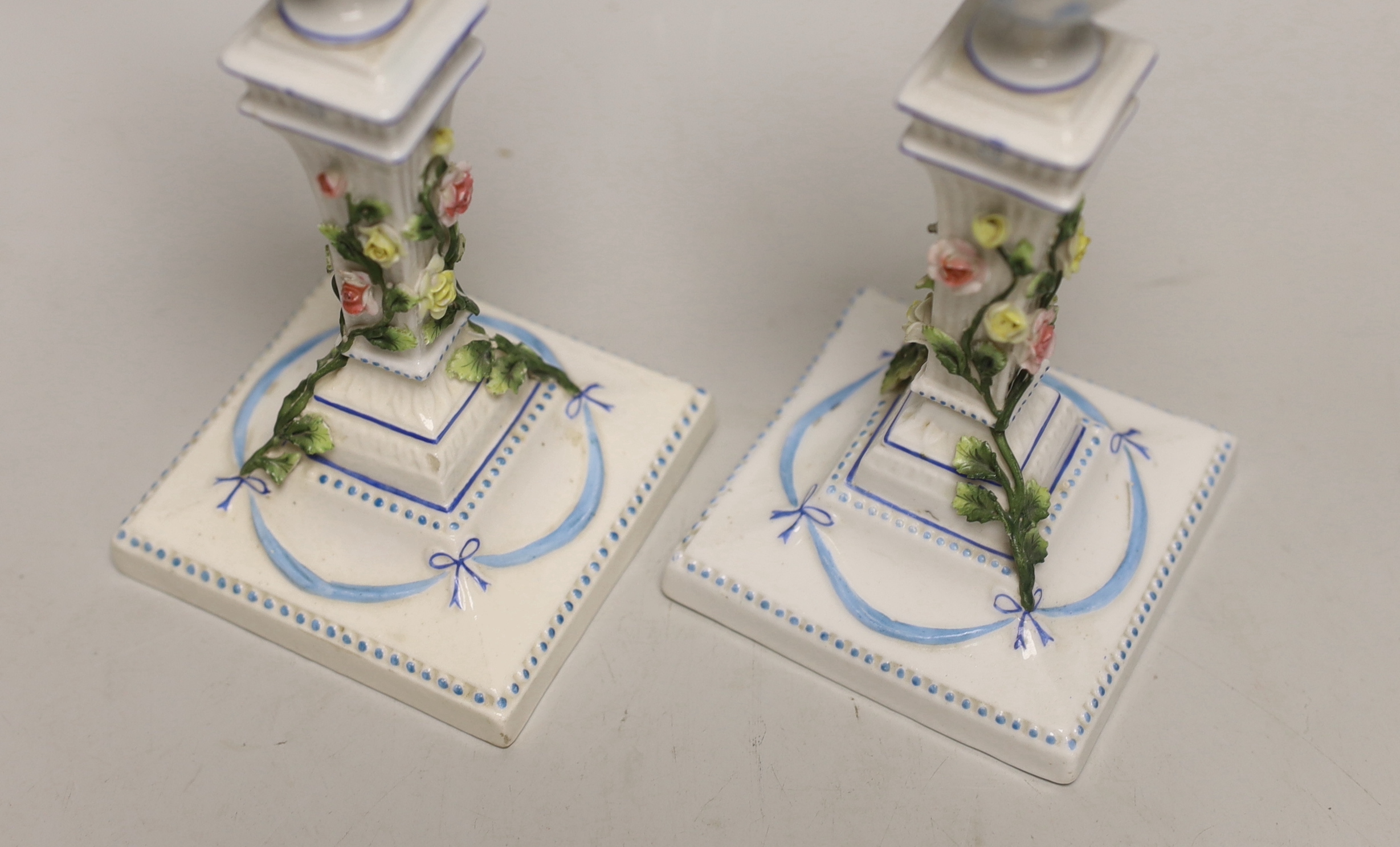 A pair of German porcelain candlesticks, marked JR, with applied floral decoration, 18cm